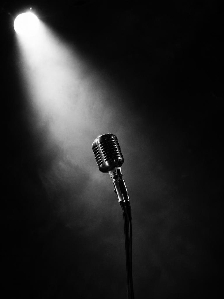 A vintage microphone standing in a spotlight
