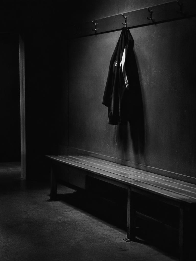 A quiet changing room with a jacket hanging above a bench